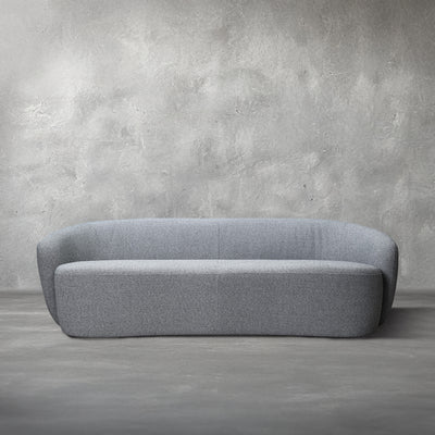 Monroe Sofa, a curved steely blue-gray performance-fabric sofa, in a living room