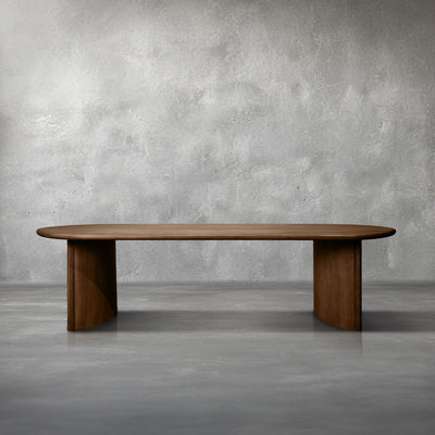 Desoto 106-inch dining table in walnut mango wood with a stadium-shaped top on half-moon slab legs
