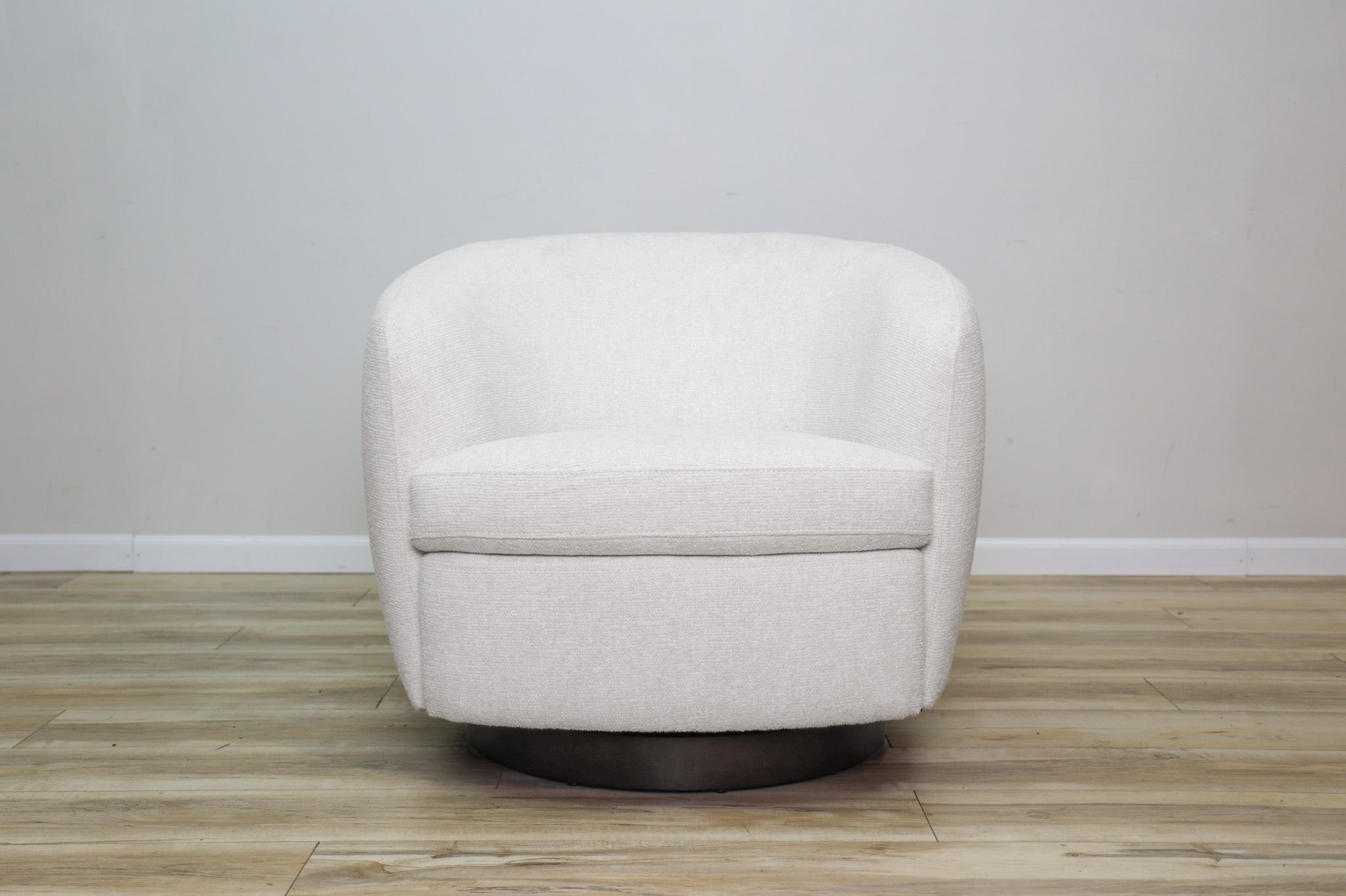 London Swivel Chair in white performance fabric with a curved barrel body on a dark wood swivel base, living room
