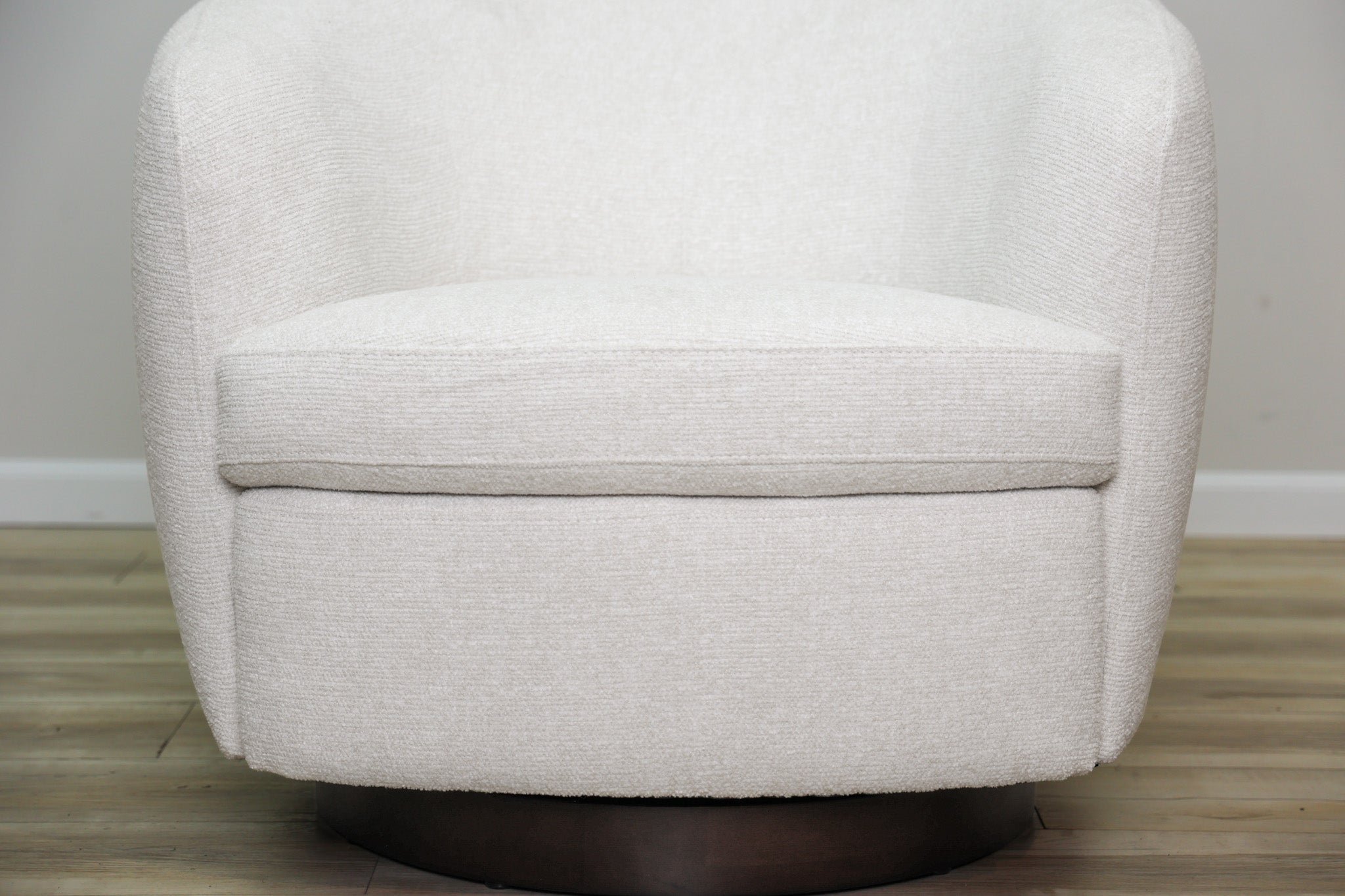 London Swivel Chair in white performance fabric with a curved barrel body on a dark wood swivel base, living room
