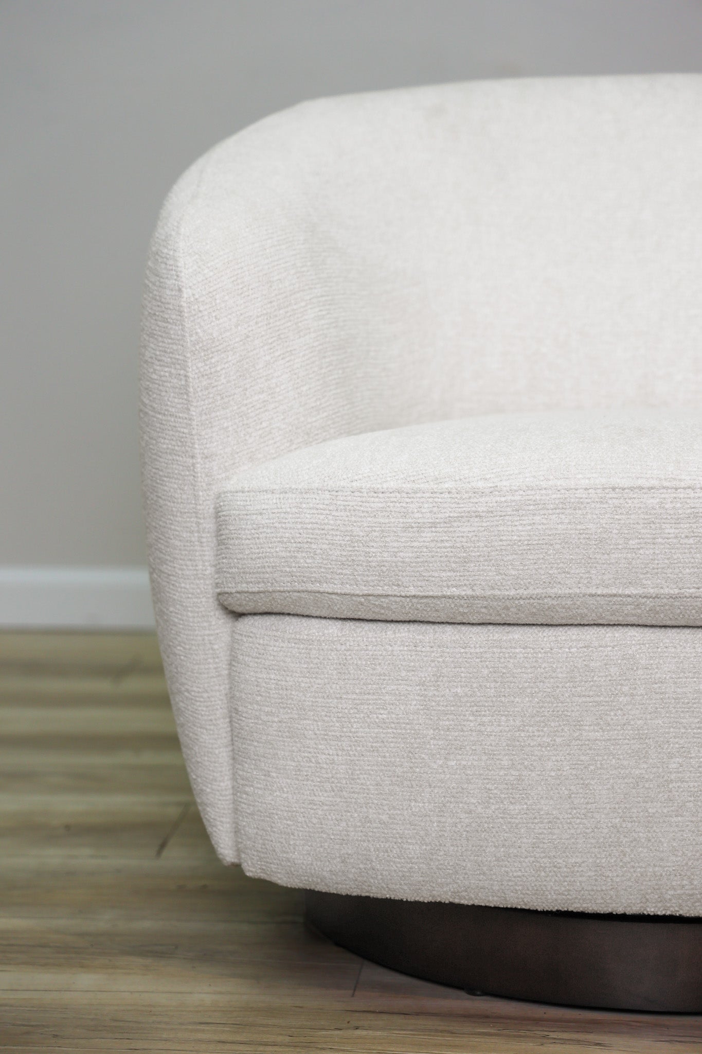 London Swivel Chair in white performance fabric with a curved barrel body on a dark wood swivel base, living room