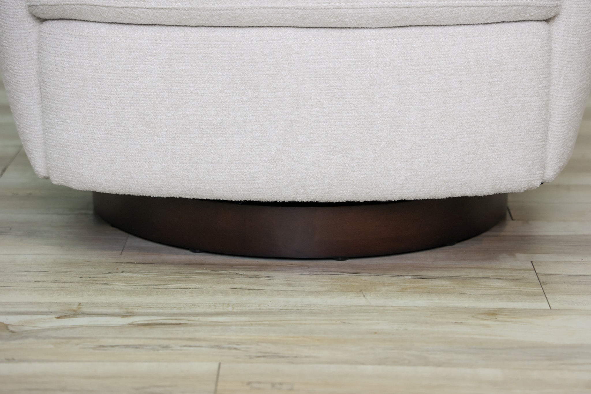London Swivel Chair in white performance fabric with a curved barrel body on a dark wood swivel base, living room