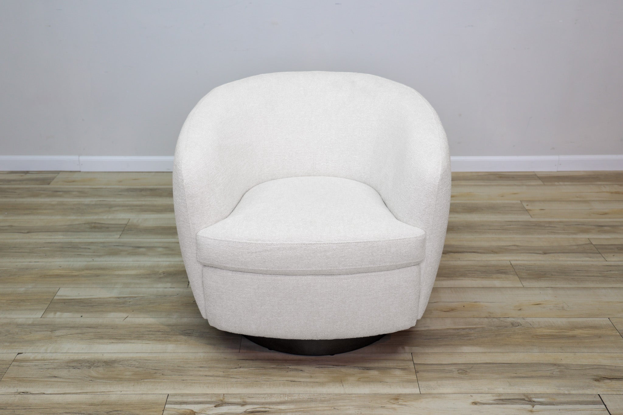 London Swivel Chair in white performance fabric with a curved barrel body on a dark wood swivel base, living room