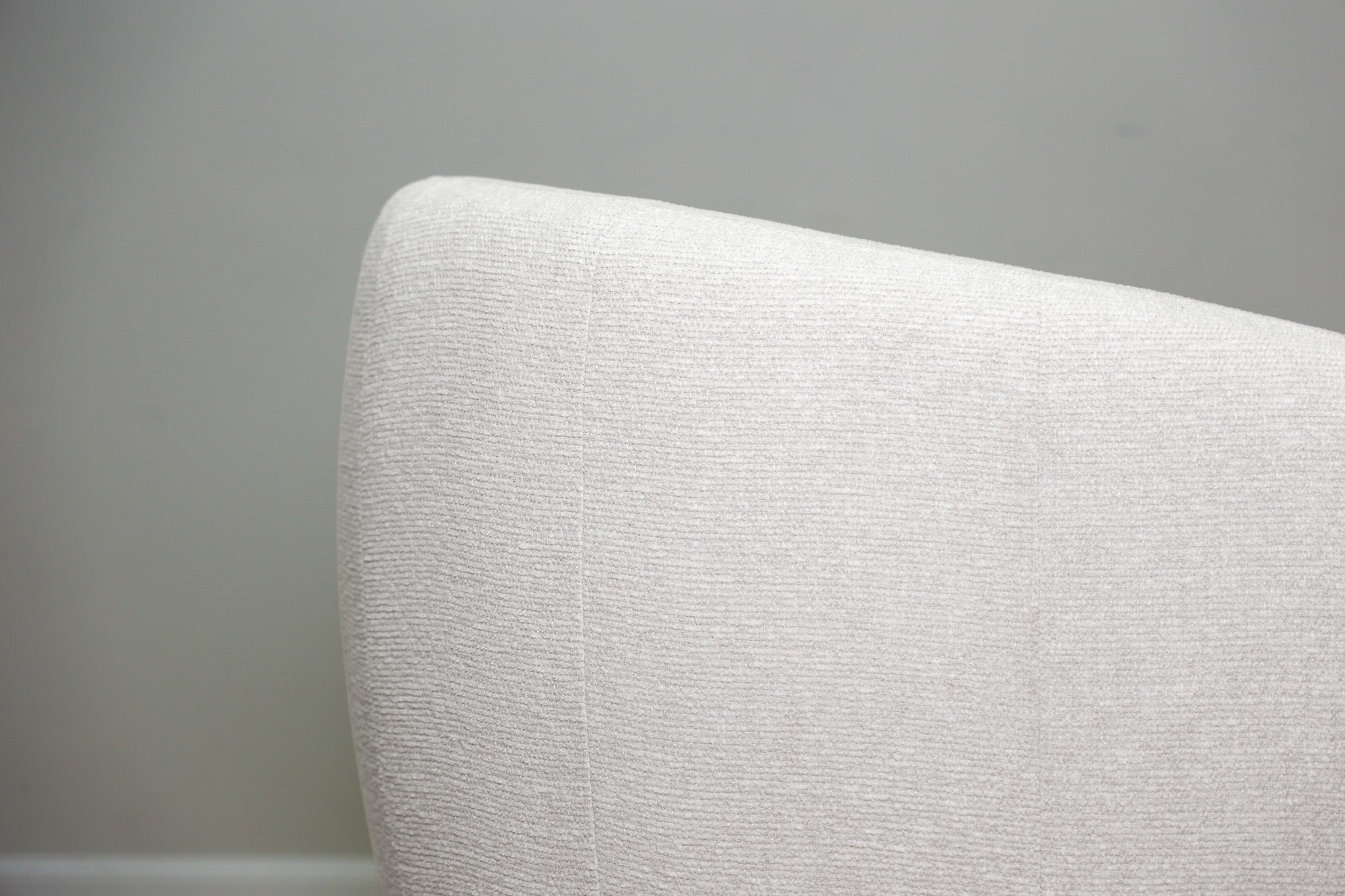 London Swivel Chair in white performance fabric with a curved barrel body on a dark wood swivel base, living room