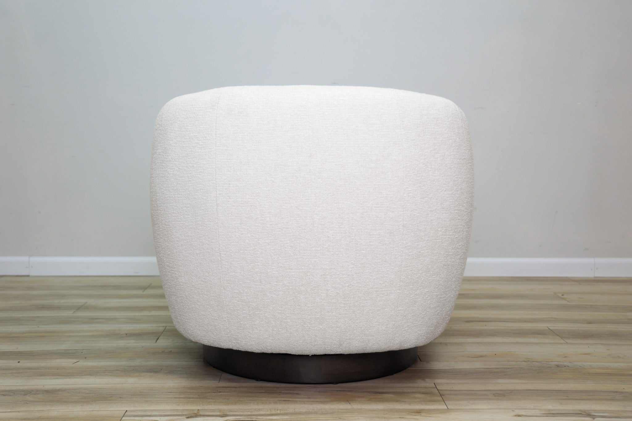 London Swivel Chair in white performance fabric with a curved barrel body on a dark wood swivel base, living room