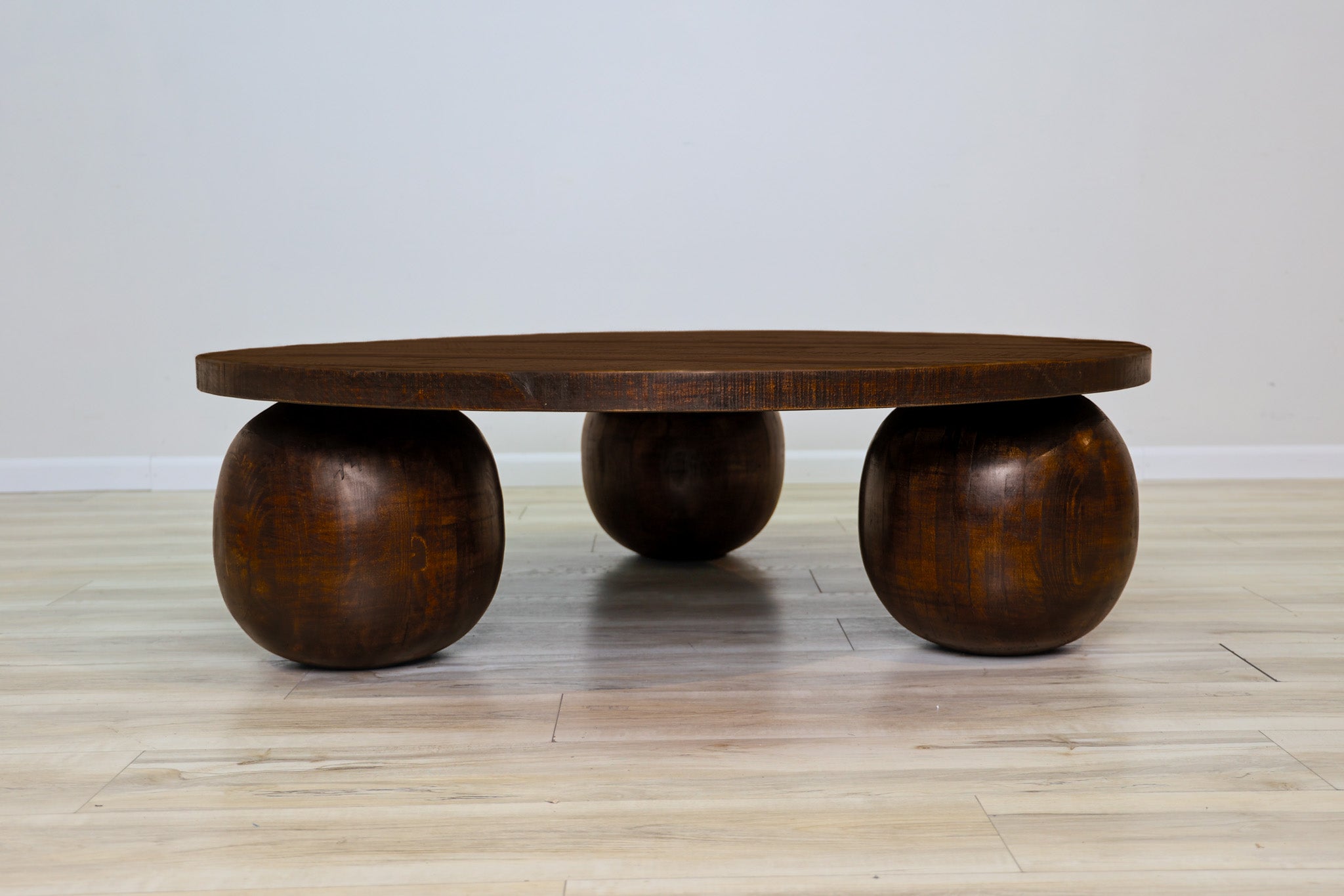 Fernandez round coffee table in solid Mexican pine with three spherical wood ball feet, living room