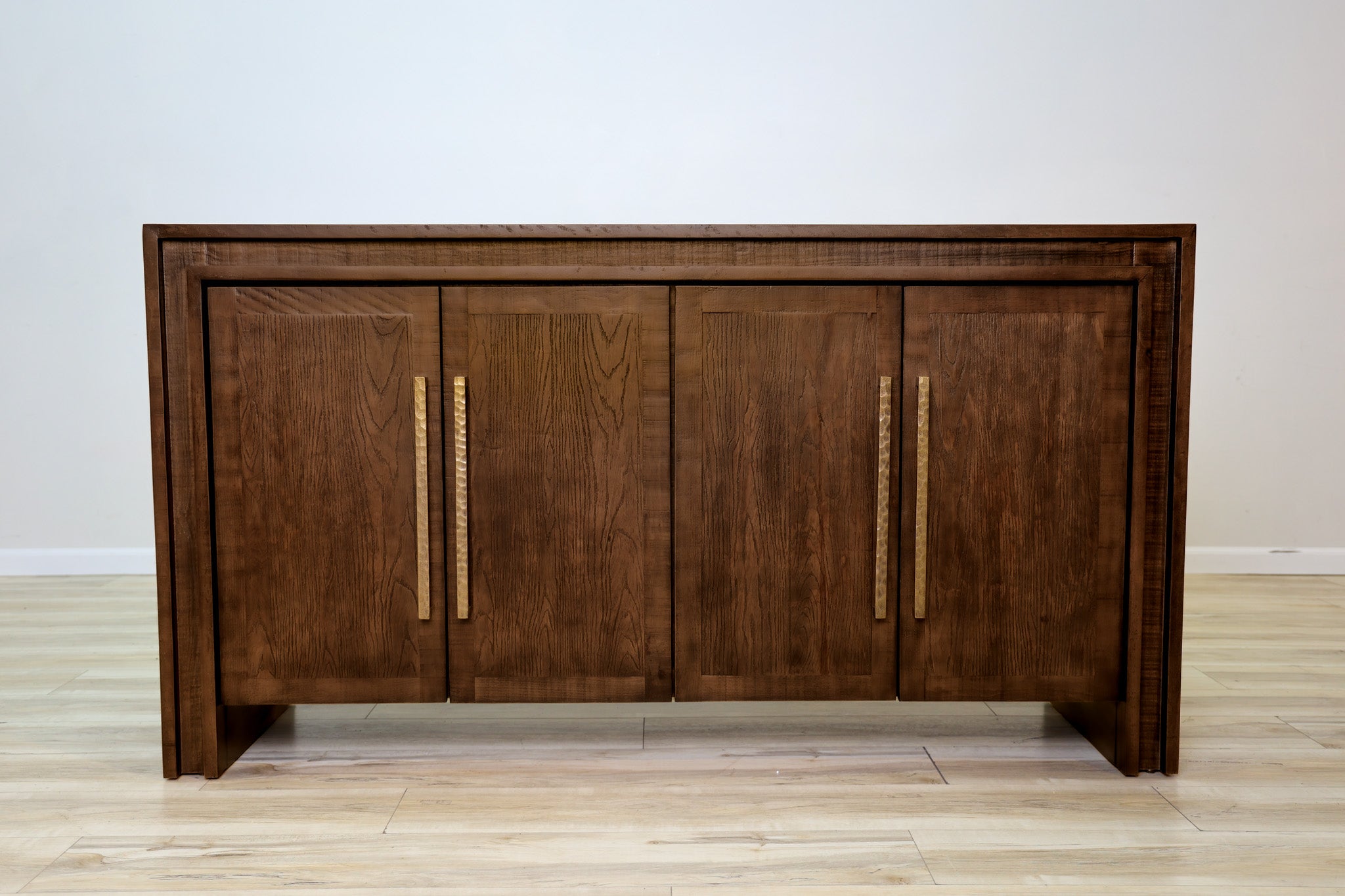 Manny 67-inch credenza in solid Mexican pine with four doors and hammered gold bar handles, living room
