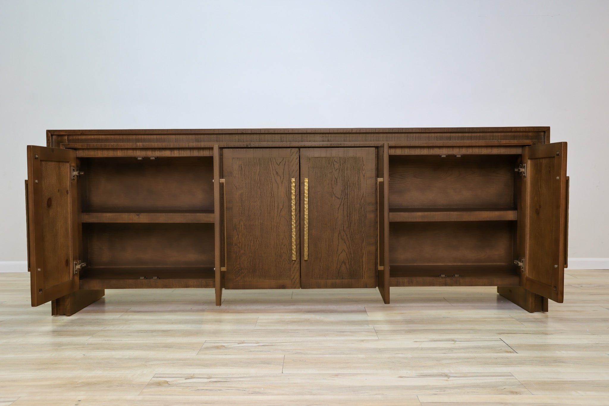 Manny 97-inch credenza in solid Mexican pine with six doors and hammered gold bar handles, living room