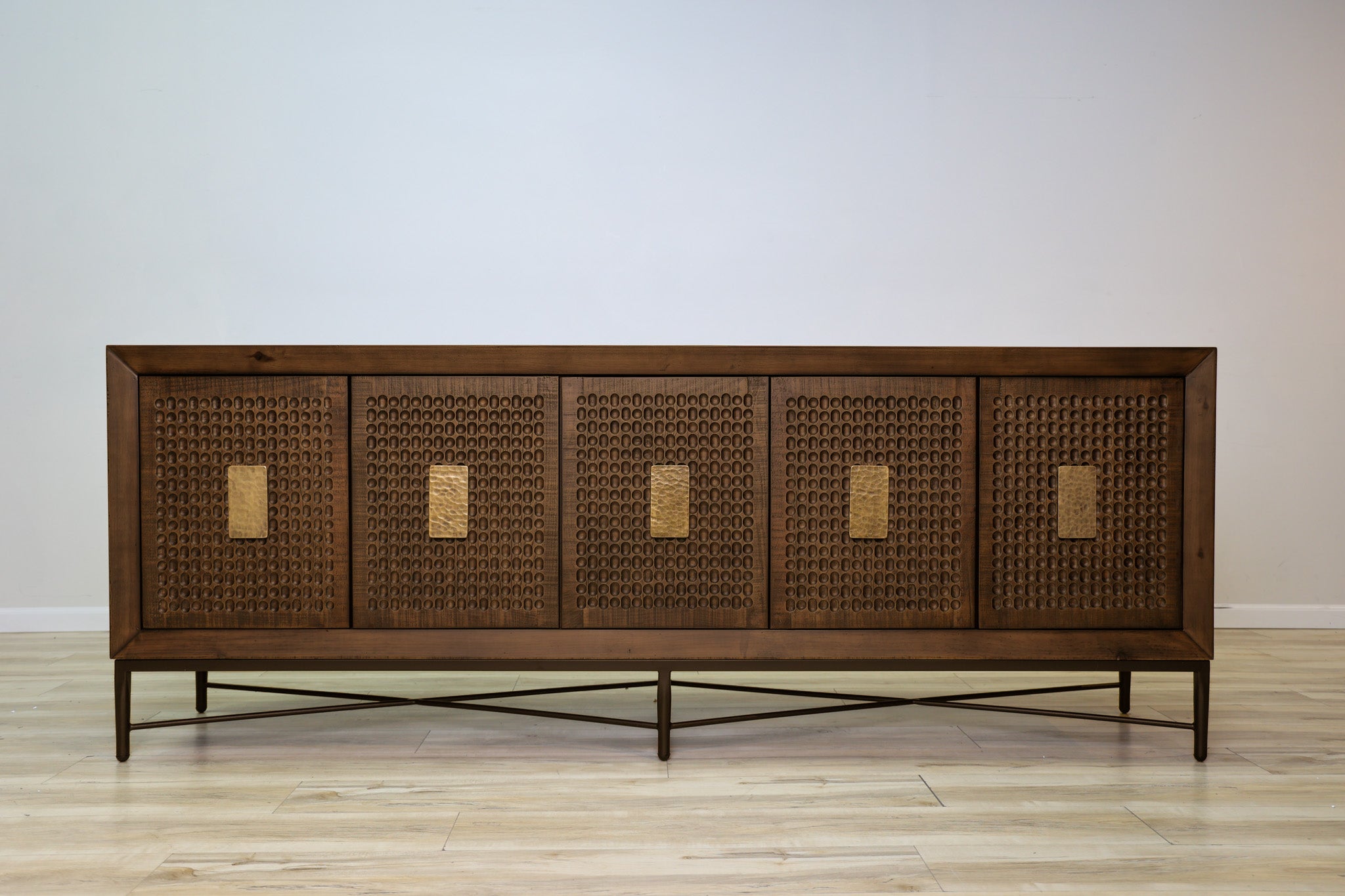 Jonathan credenza in solid Mexican pine with five carved dimpled doors, gold plate pulls, and a metal base, living room
