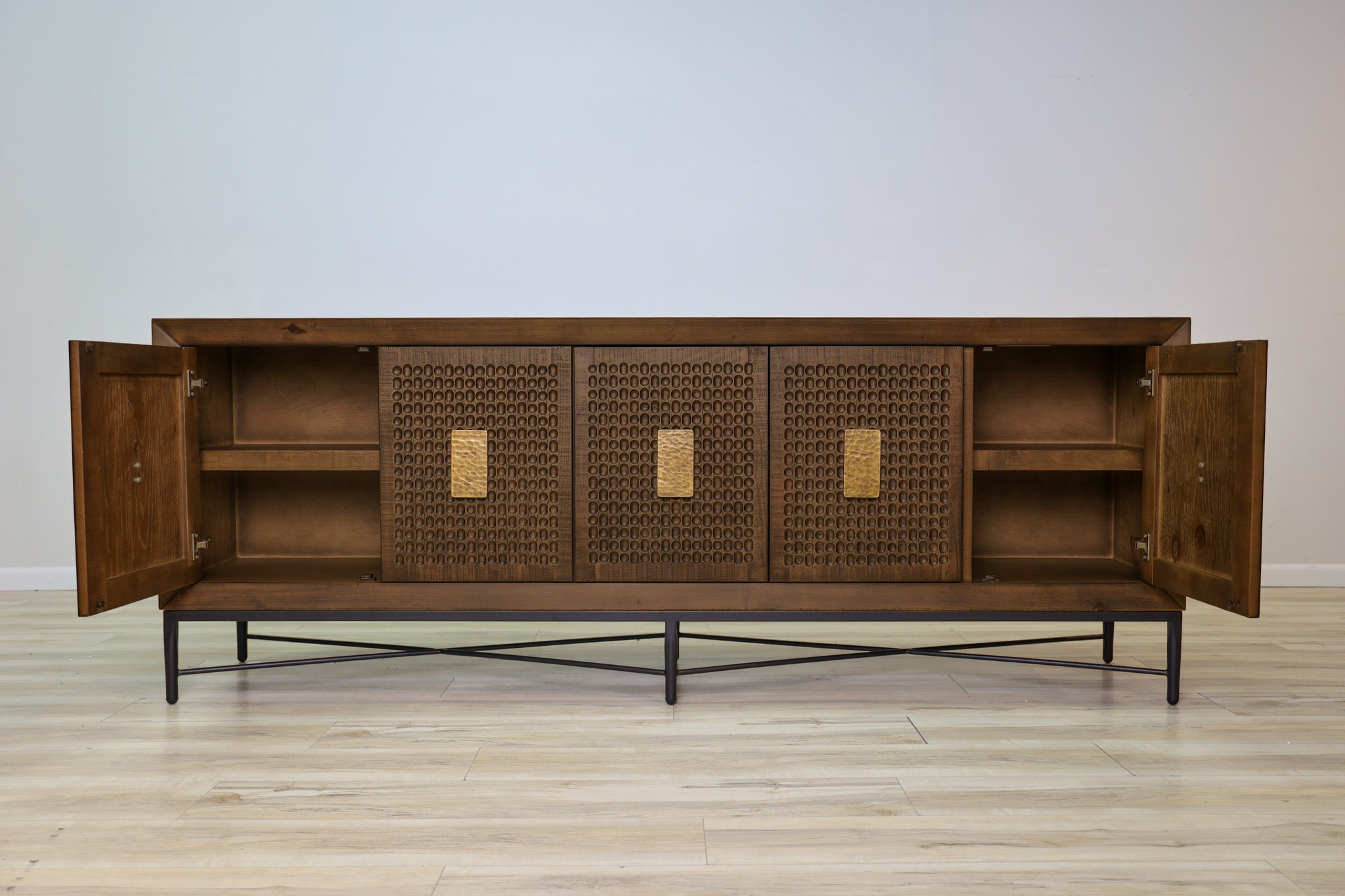 Jonathan credenza in solid Mexican pine with five carved dimpled doors, gold plate pulls, and a metal base, living room