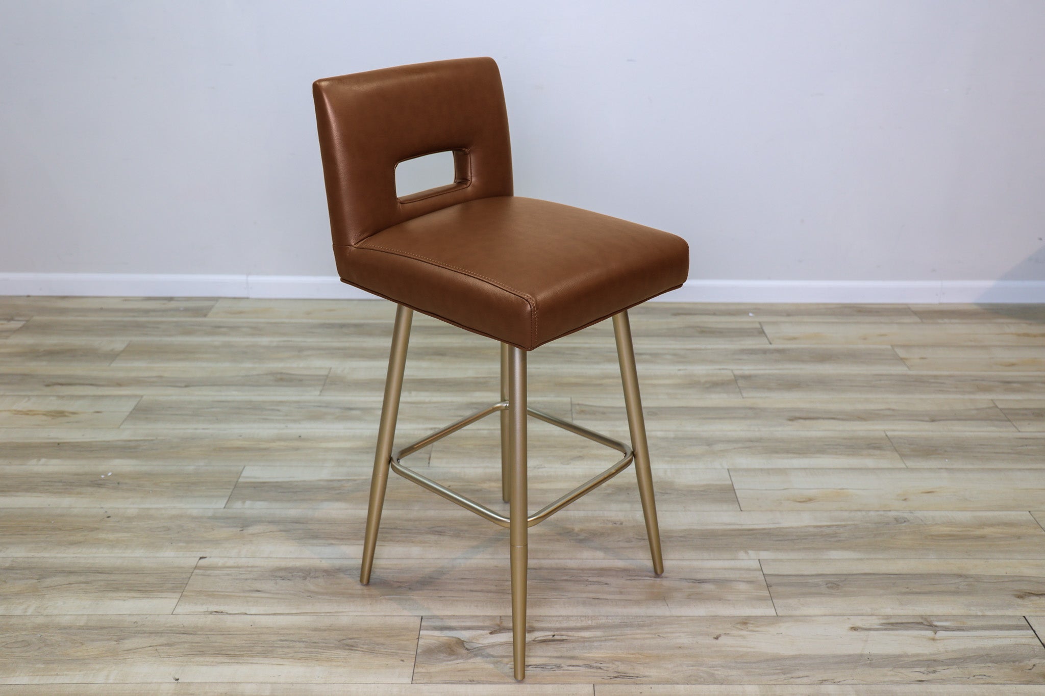 Versa Keyback adjustable barstool in cognac faux leather with a keyhole back and gold metal swivel base, kitchen bar