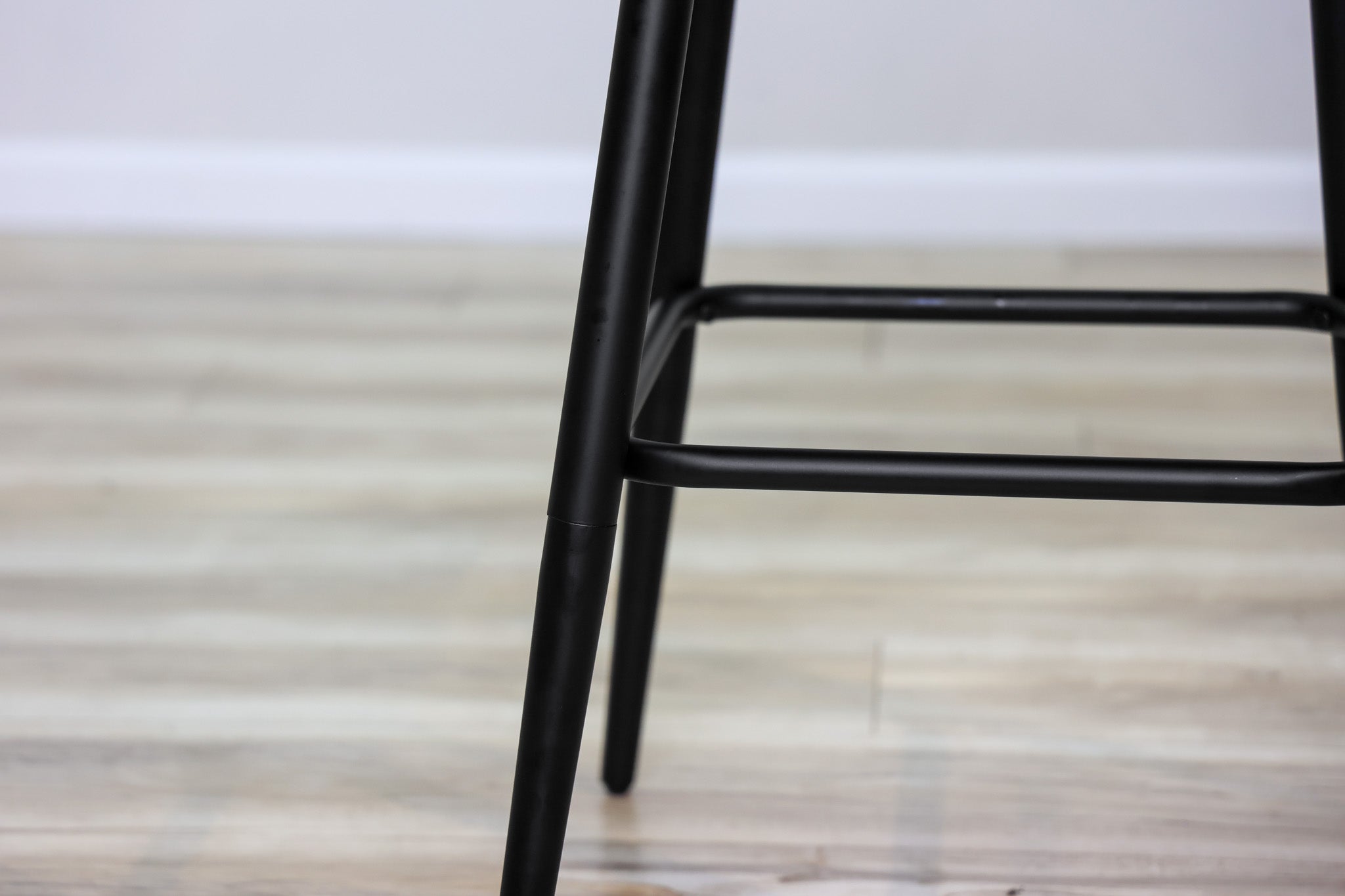 Versa backless adjustable stool in black faux leather with a black metal swivel base and footrest, kitchen bar