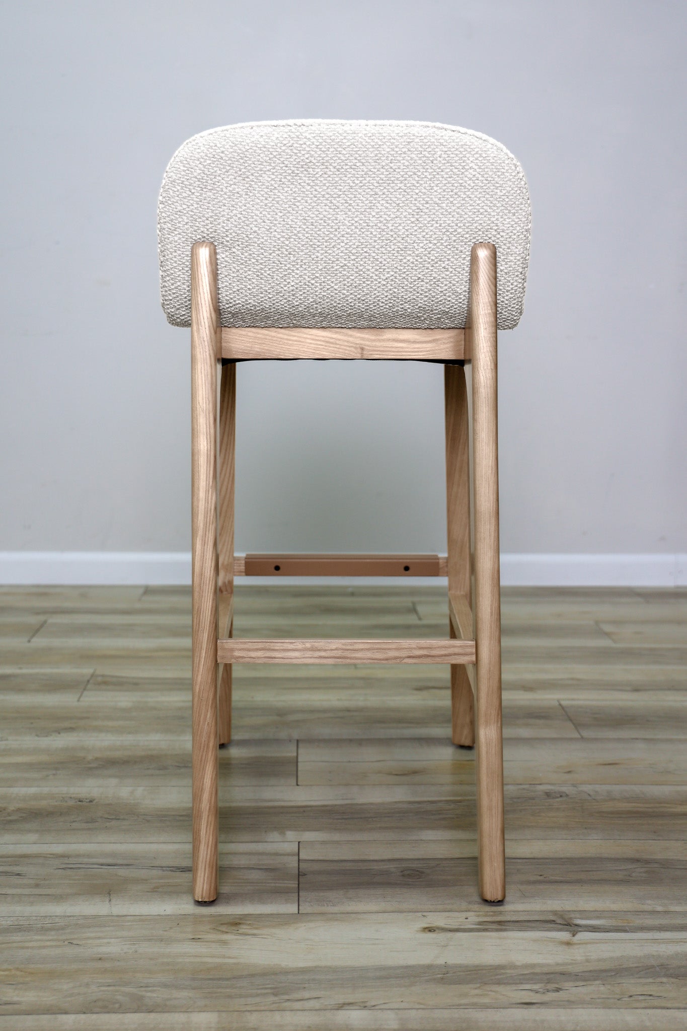 Asher barstool in beige performance fabric with a low back and natural wood legs with stretchers, kitchen bar