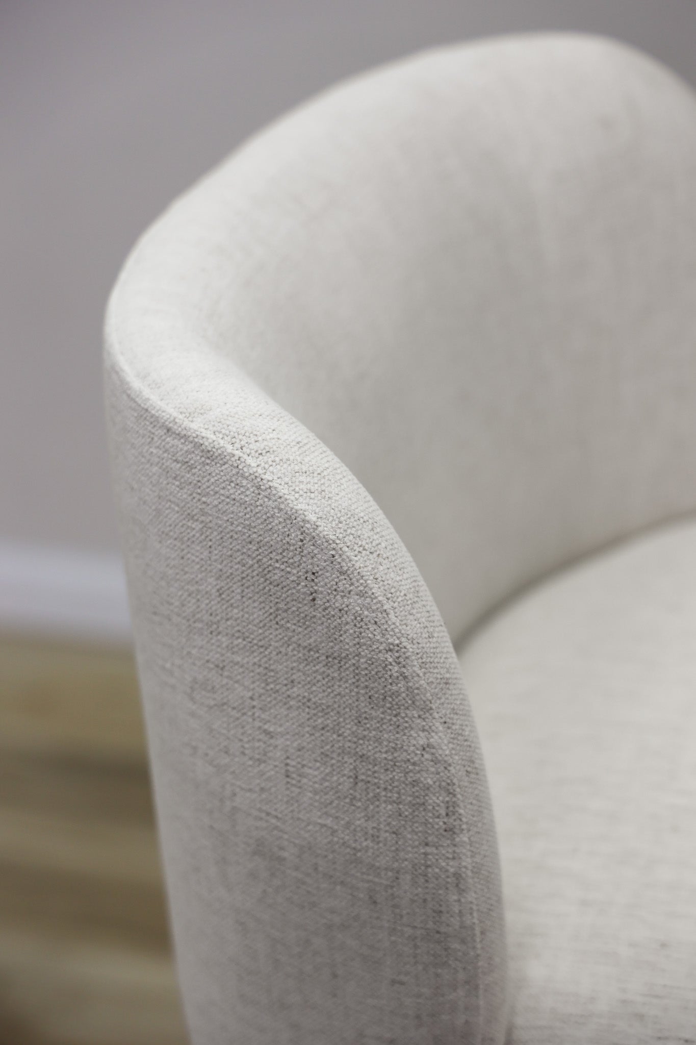 Tiffany swivel barstool in ivory Crypton fabric with natural wood legs and a black ring footrest, kitchen bar