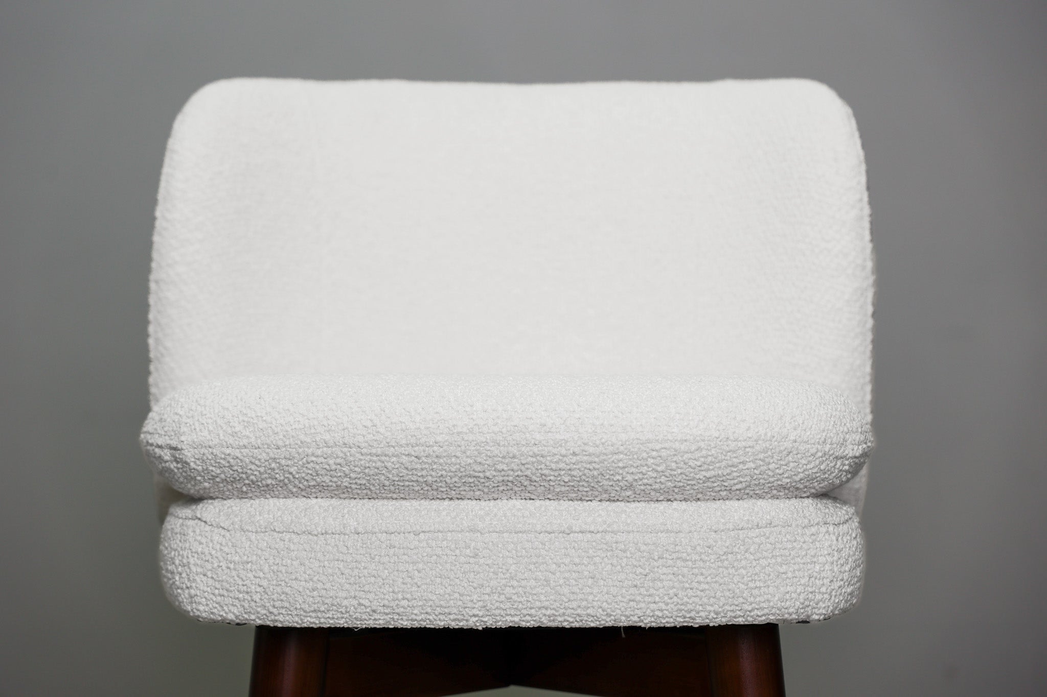Avalon swivel barstool in cream bouclé performance fabric with walnut wood legs and a black ring footrest, kitchen bar
