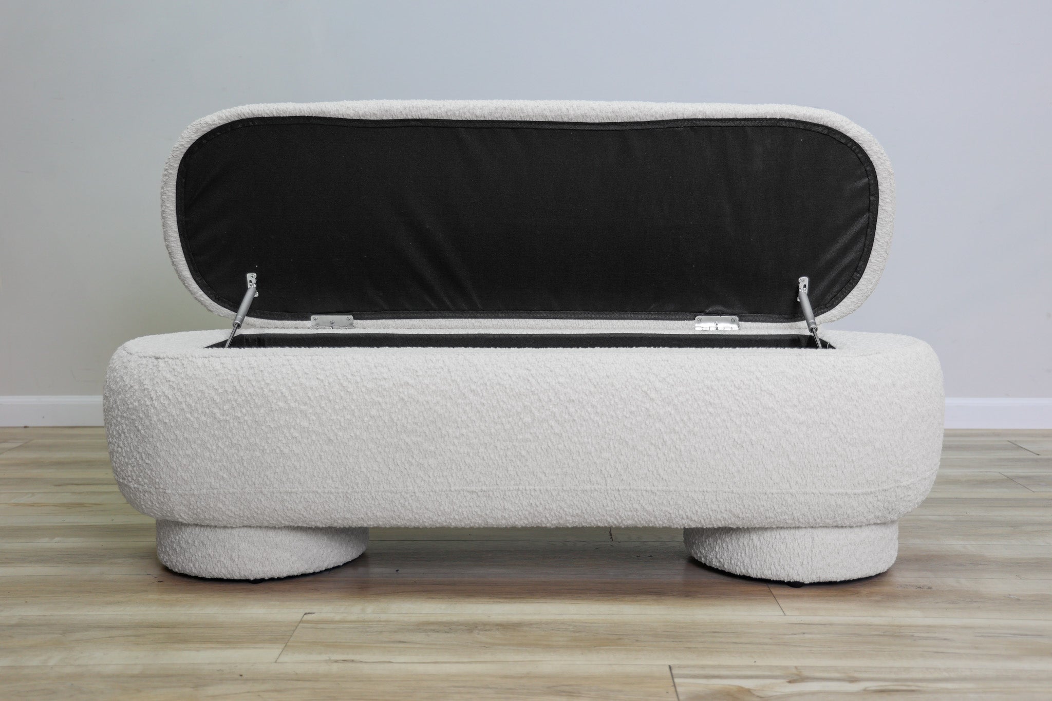 Casper storage bench in creamy white bouclé with a lift-top lid and rounded drum feet, living room