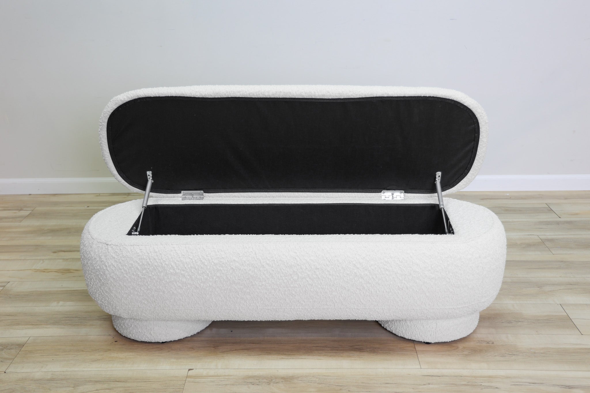 Casper storage bench in creamy white bouclé with a lift-top lid and rounded drum feet, living room
