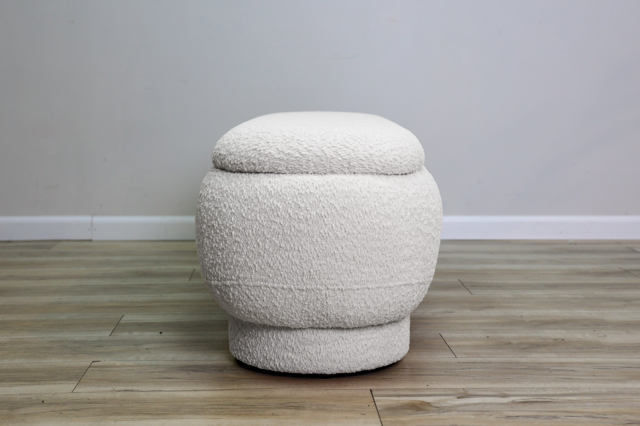 Casper storage bench in creamy white bouclé with a lift-top lid and rounded drum feet, living room