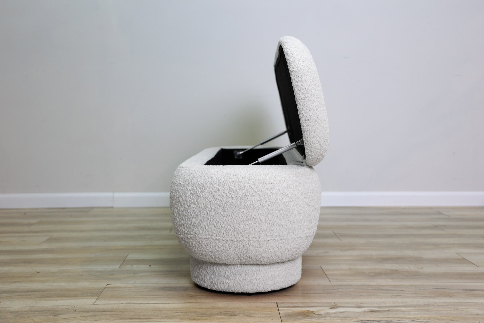 Casper storage bench in creamy white bouclé with a lift-top lid and rounded drum feet, living room