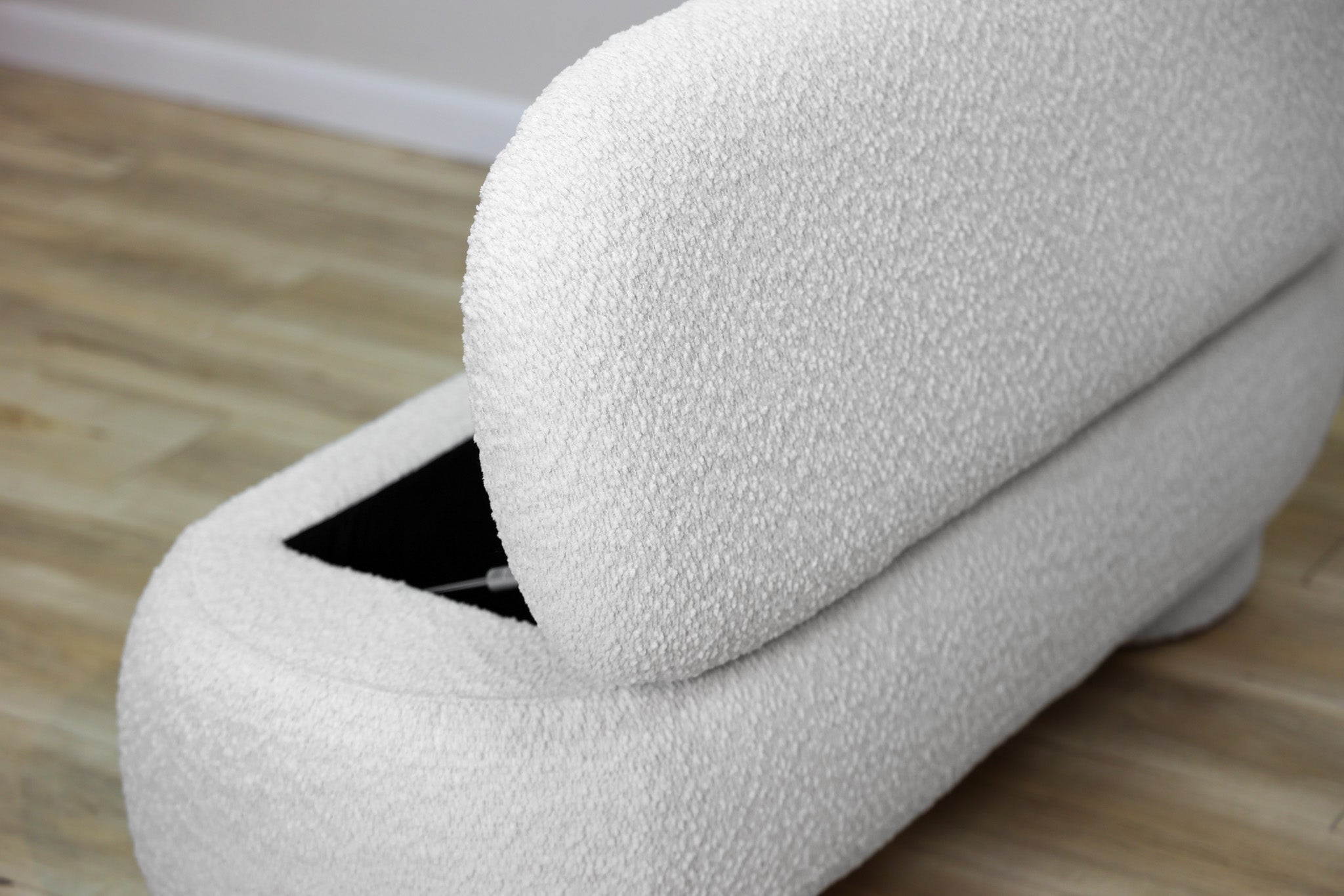 Casper storage bench in creamy white bouclé with a lift-top lid and rounded drum feet, living room