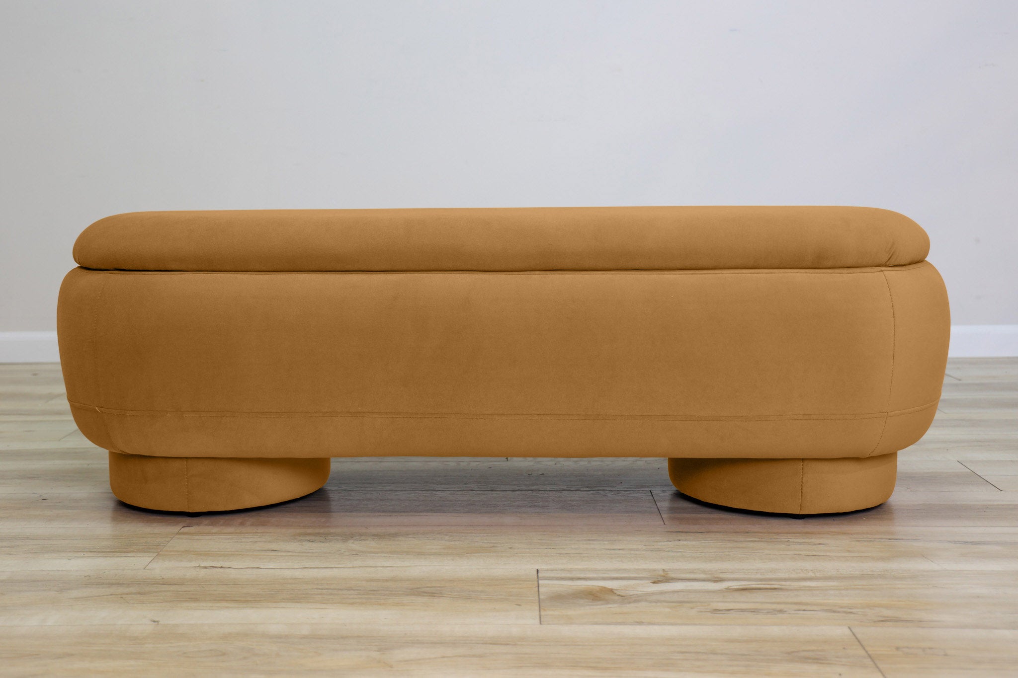 Dorian storage bench in golden velvet with a lift-top lid open to hidden storage and rounded drum feet, living room