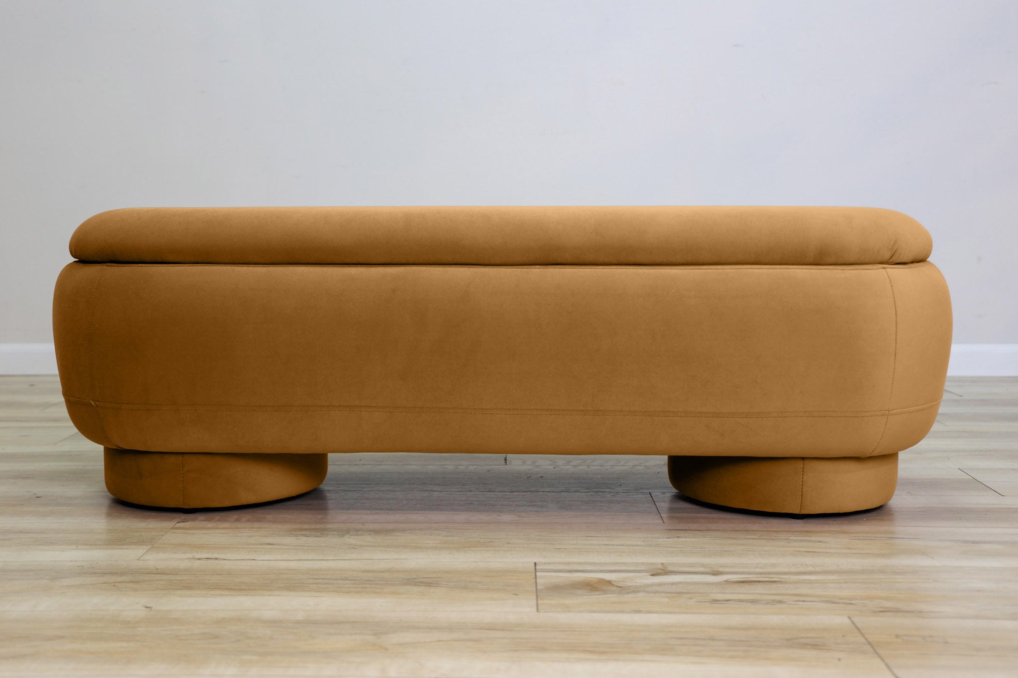 Dorian storage bench in golden velvet with a lift-top lid open to hidden storage and rounded drum feet, living room