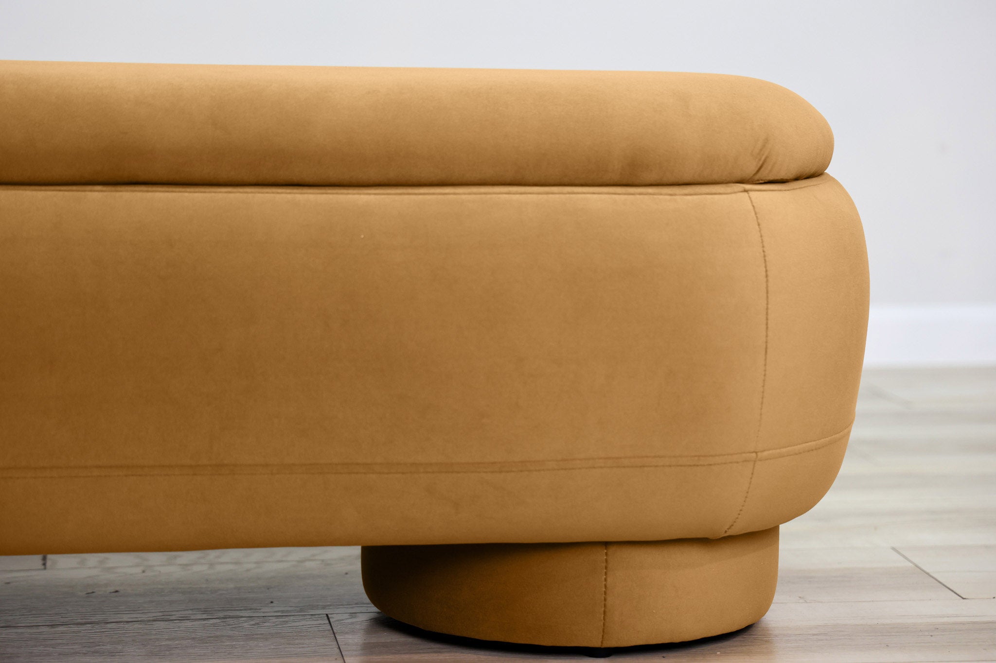 Dorian storage bench in golden velvet with a lift-top lid open to hidden storage and rounded drum feet, living room
