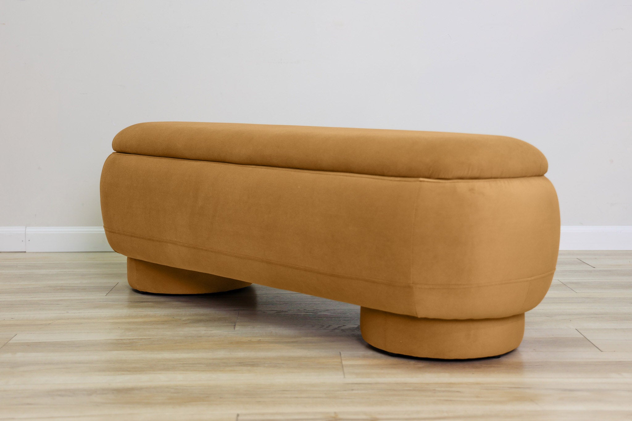Dorian storage bench in golden velvet with a lift-top lid open to hidden storage and rounded drum feet, living room