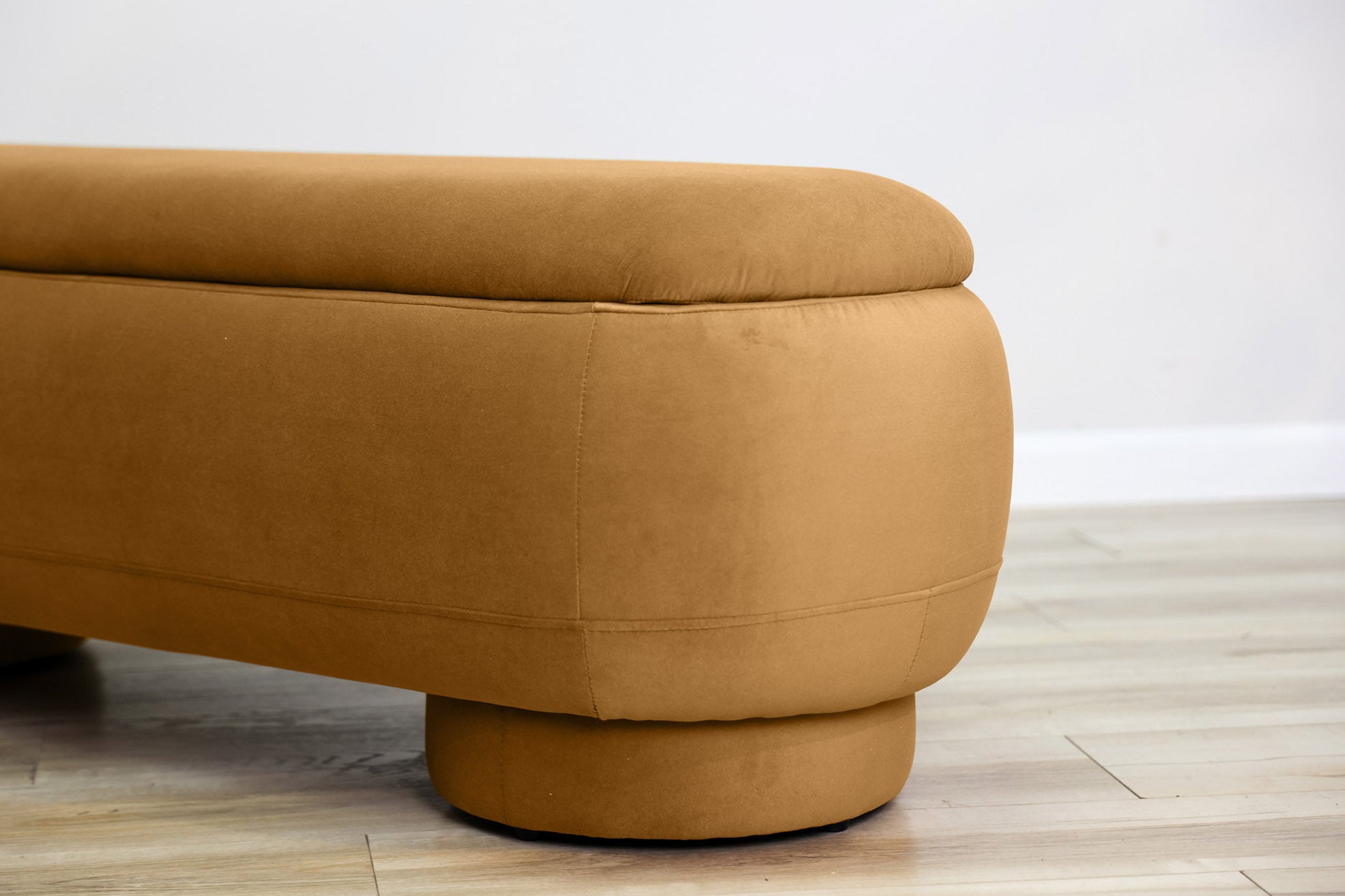 Dorian storage bench in golden velvet with a lift-top lid open to hidden storage and rounded drum feet, living room