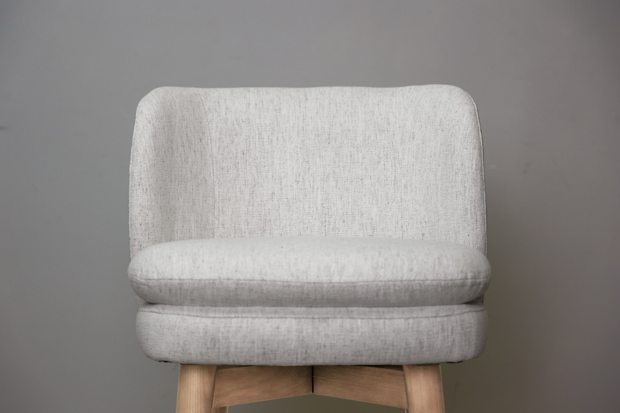 Tiffany swivel counter stool in ivory Crypton fabric with natural wood legs and a black ring footrest, kitchen counter