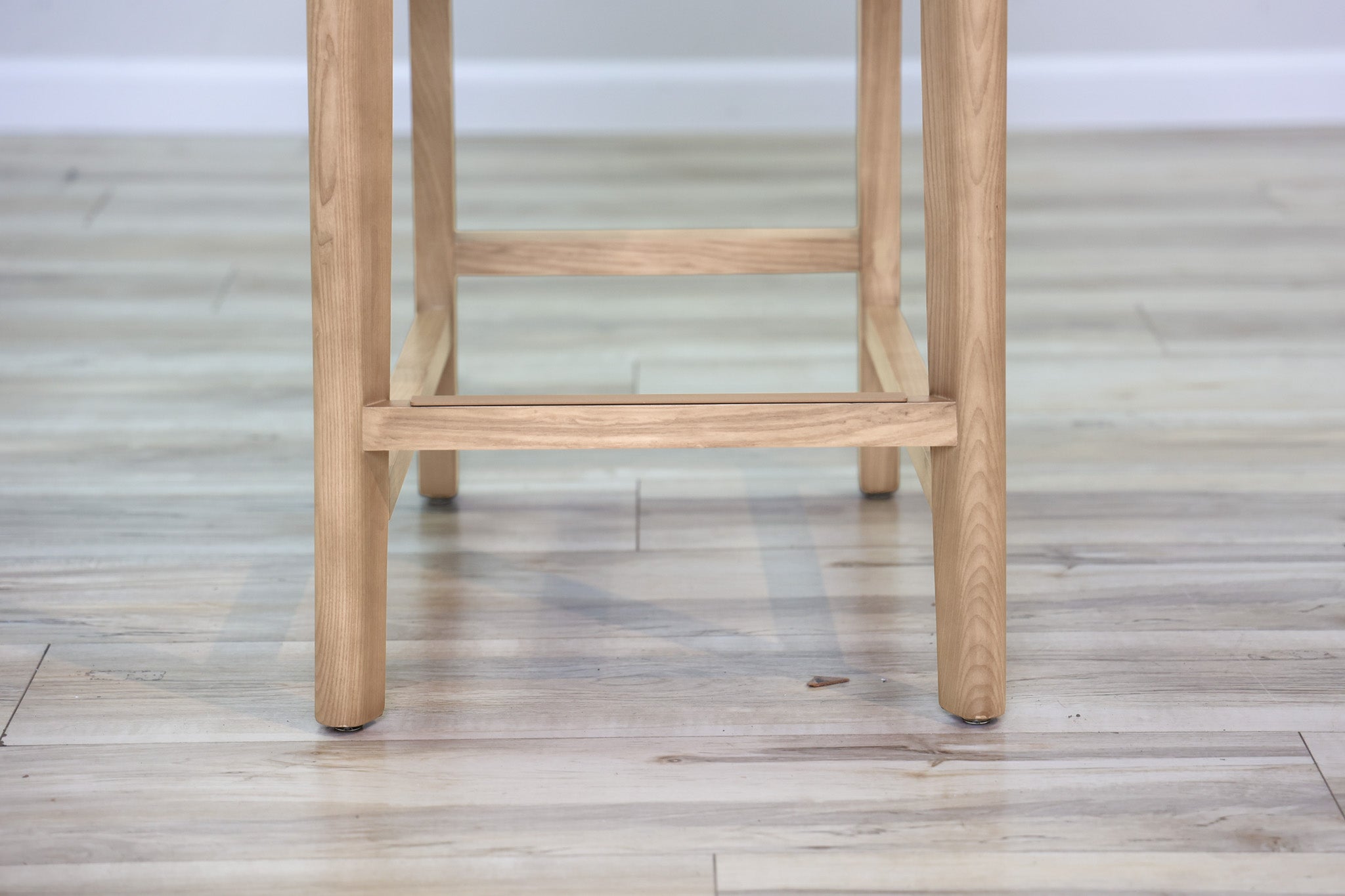 Asher counter stool in beige performance fabric with a low back and natural wood legs with stretchers, kitchen counter
