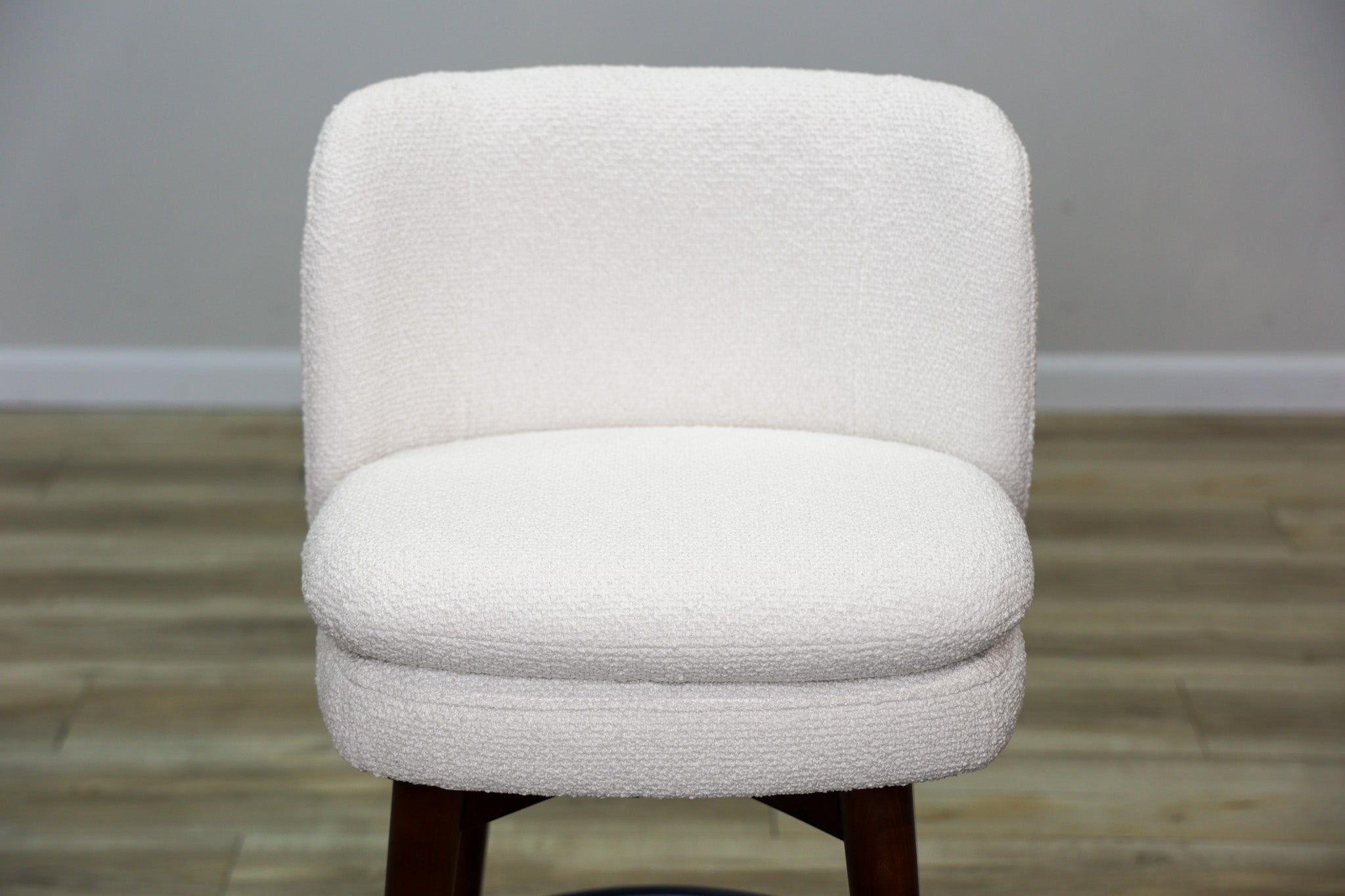Avalon swivel counter stool in cream bouclé performance fabric with walnut wood legs and a black ring footrest, kitchen counter