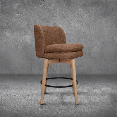Elmer counter stool in rust performance fabric with a low wraparound back, natural wood legs, and a black ring footrest, kitchen counter