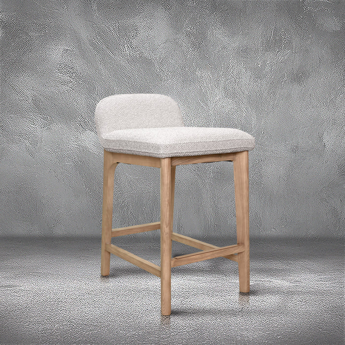 Asher counter stool in beige performance fabric with a low back and natural wood legs with stretchers, kitchen counter