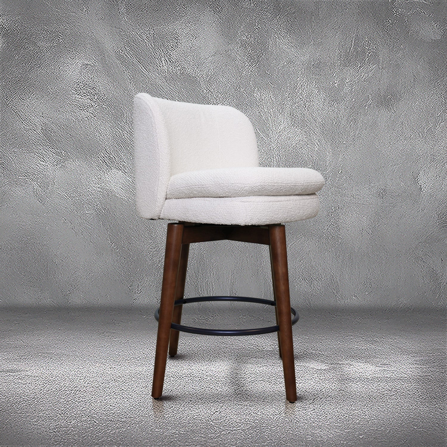 Avalon swivel counter stool in cream bouclé performance fabric with walnut wood legs and a black ring footrest, kitchen counter