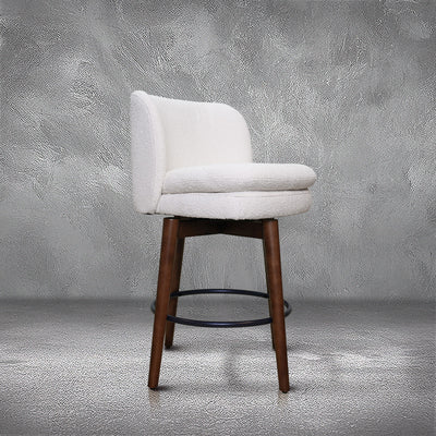 Avalon swivel counter stool in cream bouclé performance fabric with walnut wood legs and a black ring footrest, kitchen counter