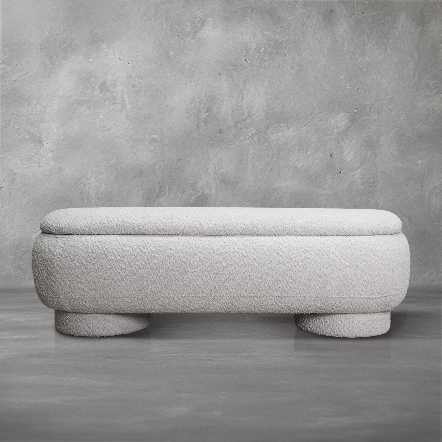Casper storage bench in creamy white bouclé with a lift-top lid and rounded drum feet, living room