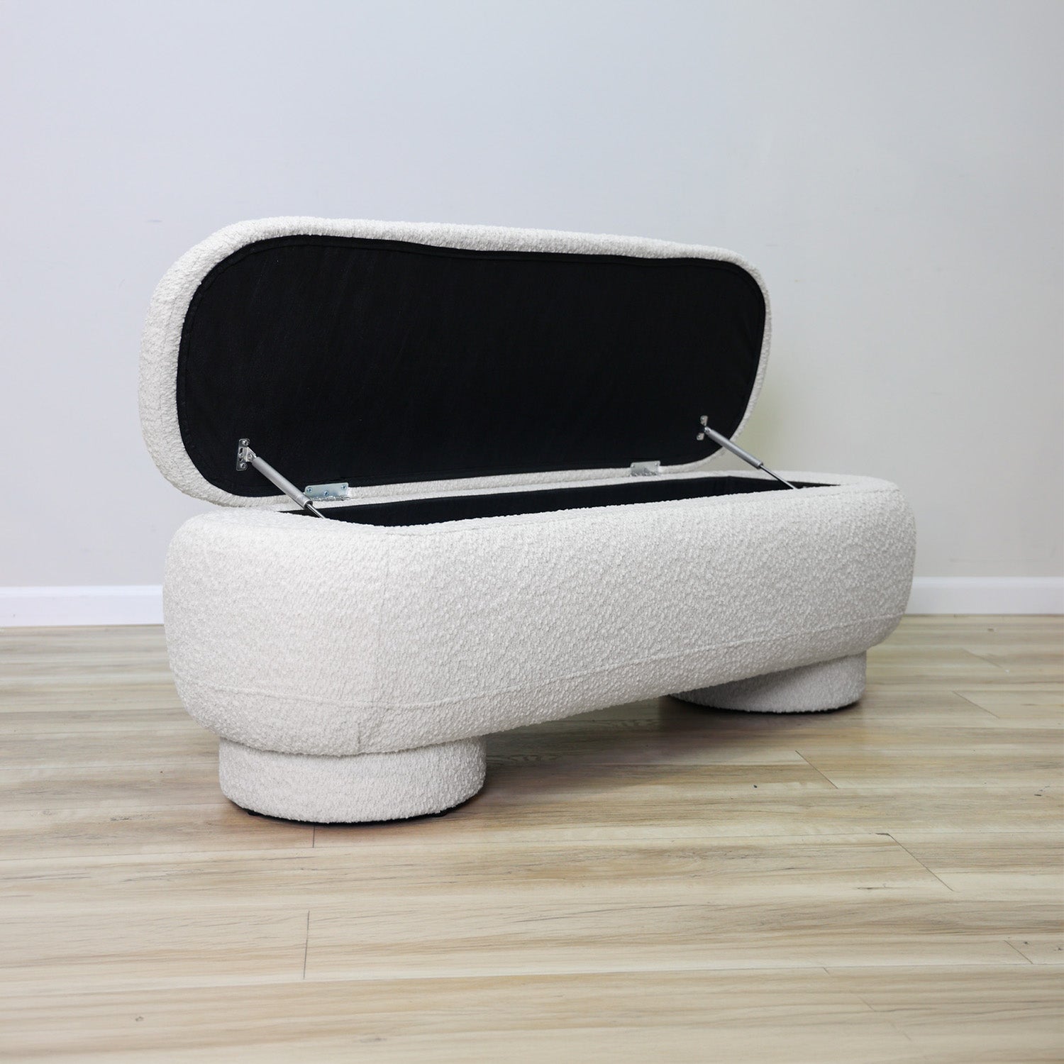 Casper storage bench in creamy white bouclé with a lift-top lid and rounded drum feet, living room