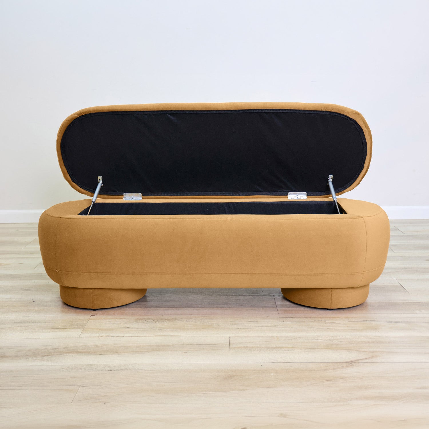 Dorian storage bench in golden velvet with a lift-top lid open to hidden storage and rounded drum feet, living room