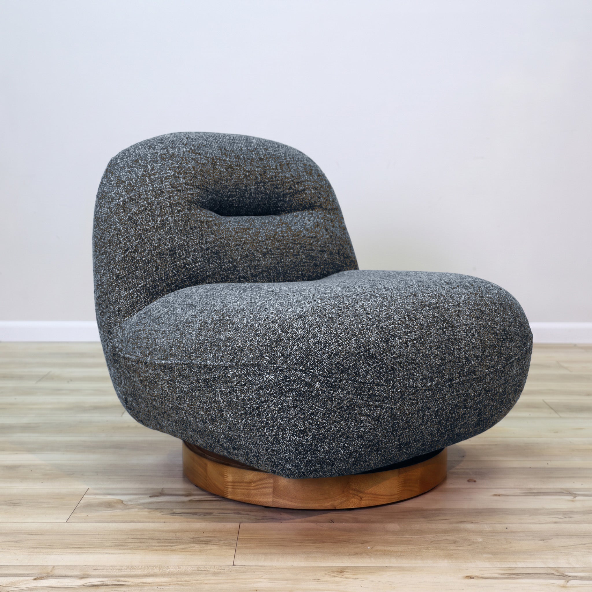 Holmes Beach swivel accent chair in textured blue performance fabric with caramel fibers on a round wood swivel base, living room