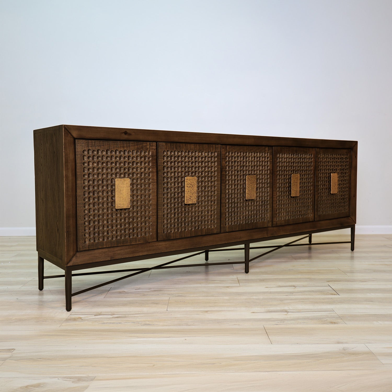 Jonathan credenza in solid Mexican pine with five carved dimpled doors, gold plate pulls, and a metal base, living room