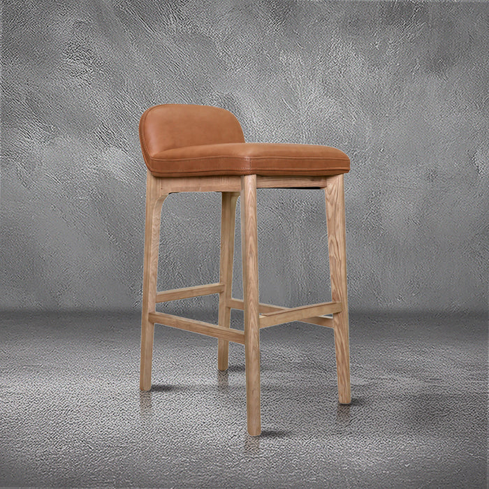 Sable barstool in cognac leather with a low back and natural wood legs with stretchers, kitchen bar