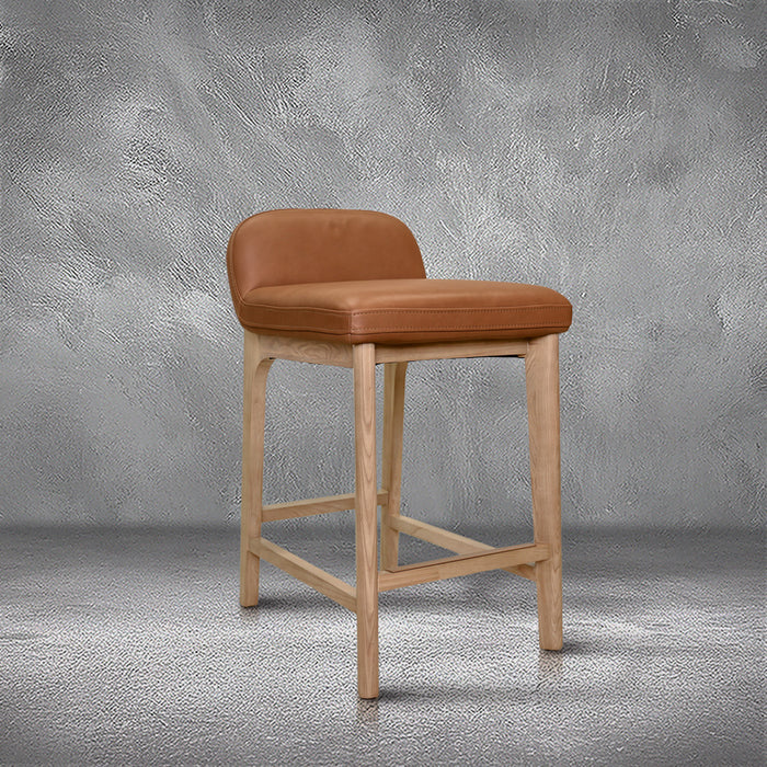 Sable counter stool in cognac leather with a low back and natural wood legs with stretchers, kitchen counter
