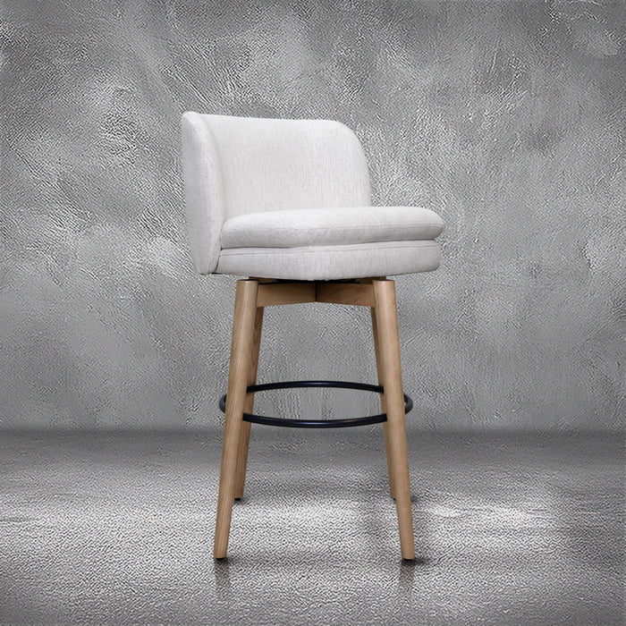 Tiffany swivel barstool in ivory Crypton fabric with natural wood legs and a black ring footrest, kitchen bar