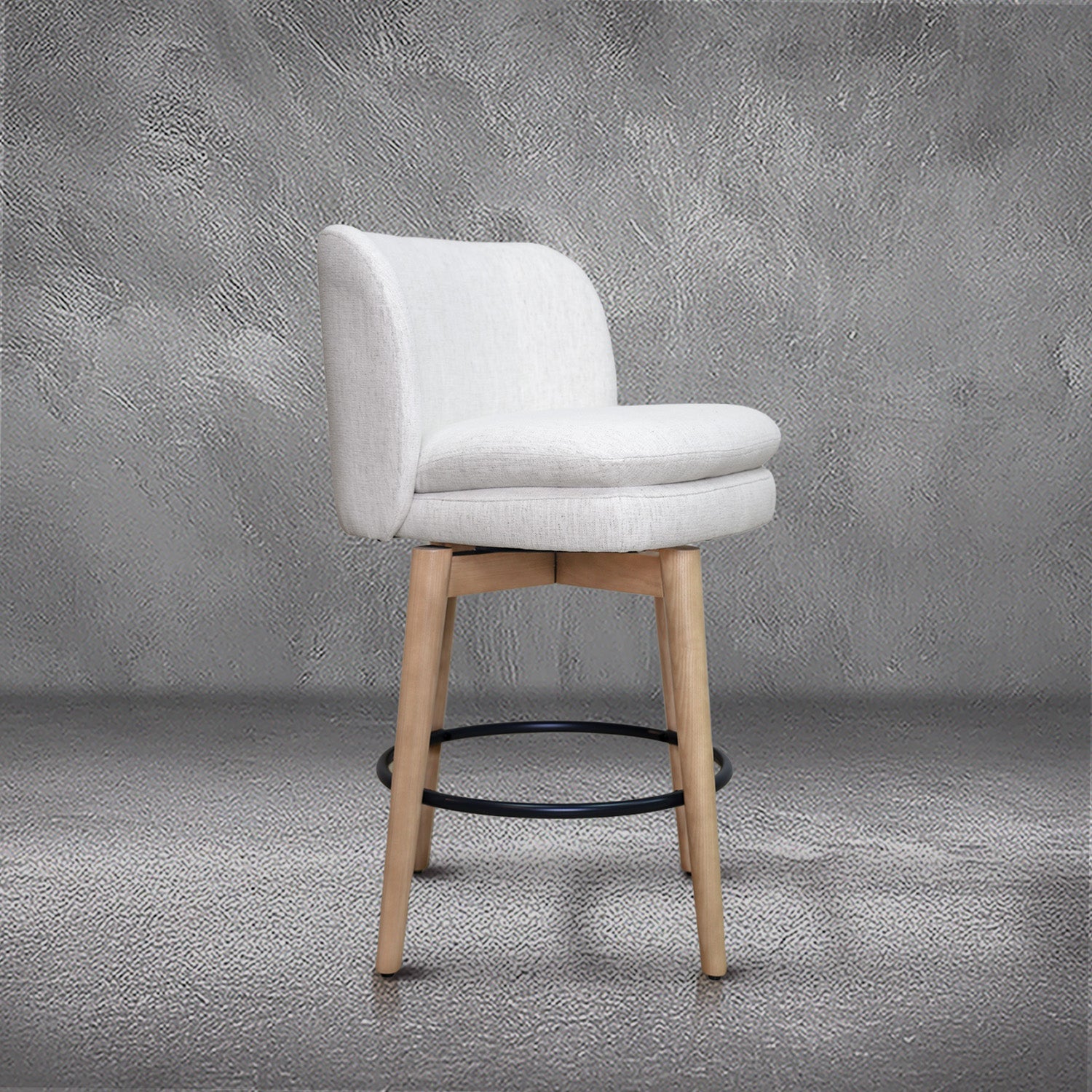 Tiffany swivel counter stool in ivory Crypton fabric with natural wood legs and a black ring footrest, kitchen counter