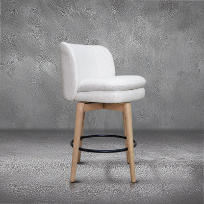 Tiffany swivel counter stool in ivory Crypton fabric with natural wood legs and a black ring footrest, kitchen counter