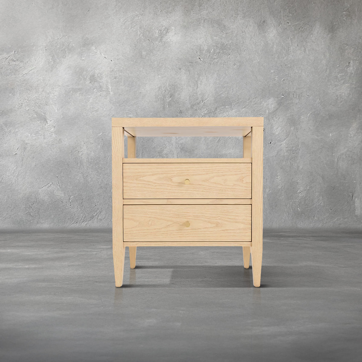 Willow nightstand in light natural wood with an open shelf over two drawers, gold knob pulls, and tapered legs, bedroom